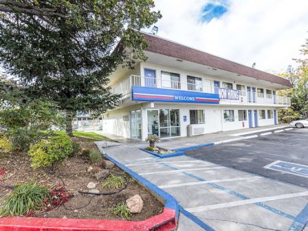 The image shows a two-story motel with a 