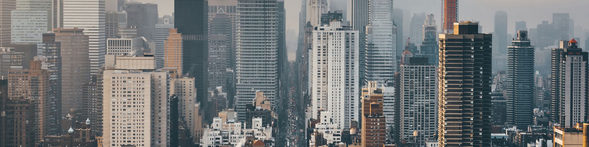 A skyline with tall buildings and skyscrapers, some shrouded in fog, creating a dramatic urban scene.