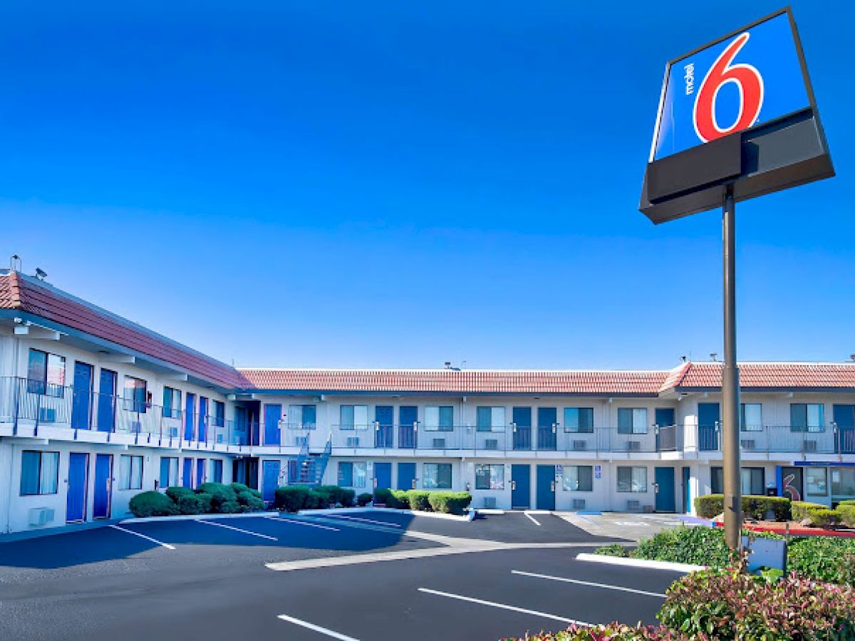 The image shows a two-story motel with a 