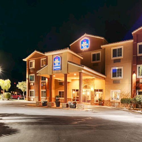 A well-lit hotel exterior at night with palm trees, featuring the bright entrance and multiple stories.