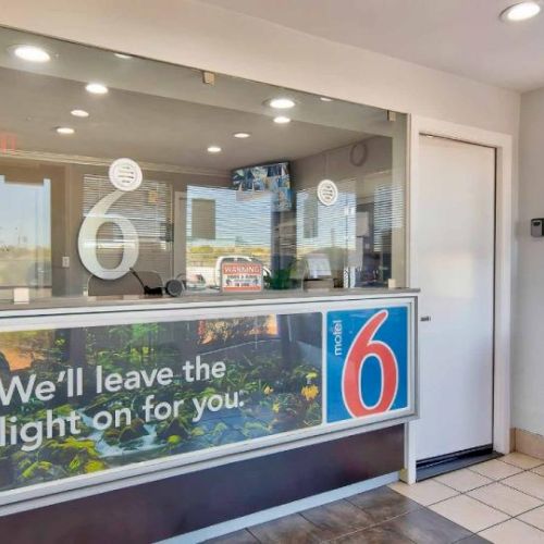 A reception area with a Motel 6 logo, a counter, and the phrase 